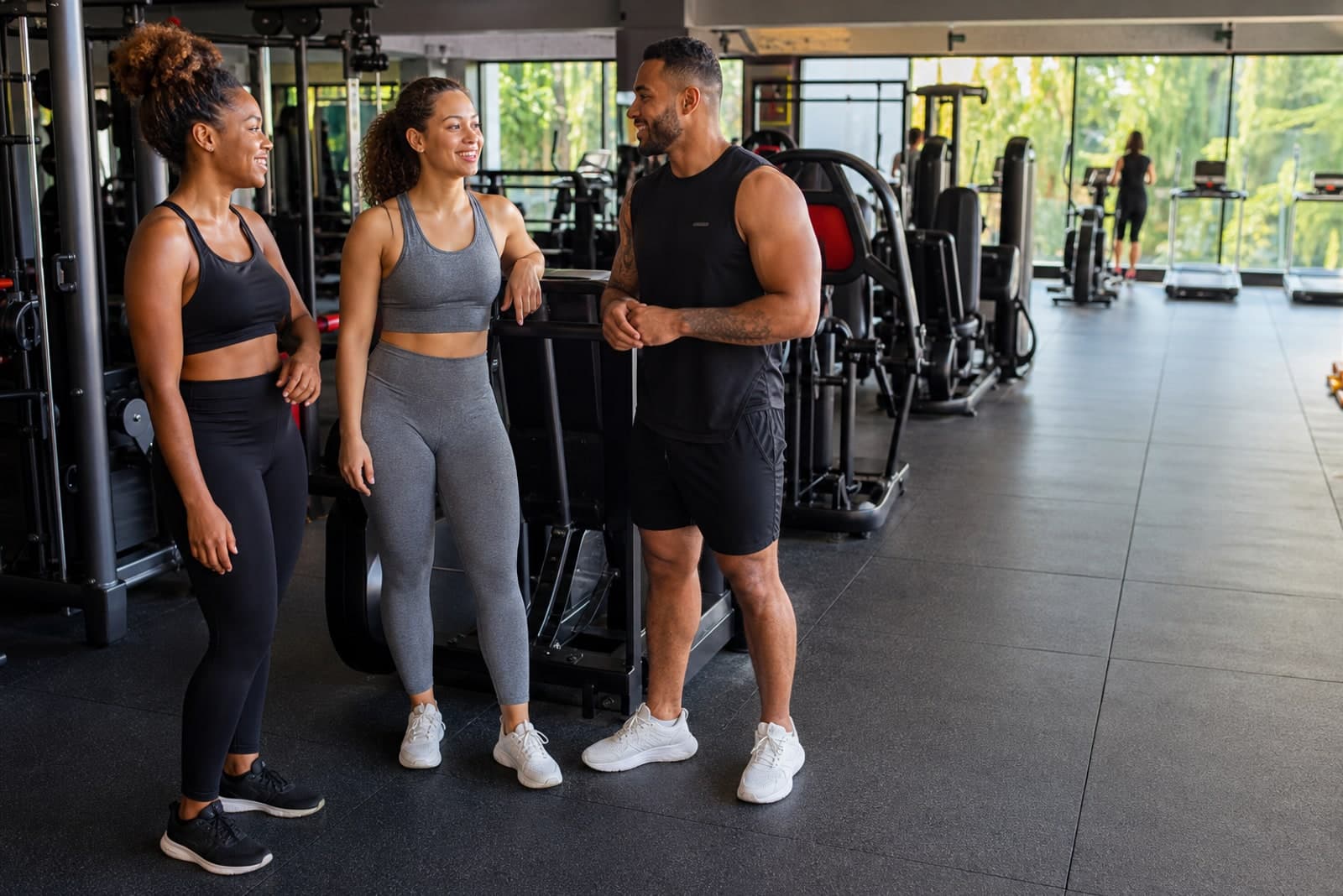 Three Caribbean gym members sharing a moment after a strength session